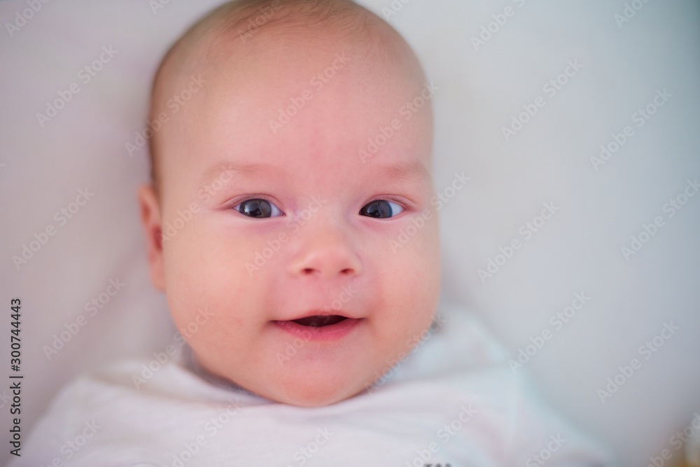  Portrait of a three-month baby. Child looking at the camera and smiling