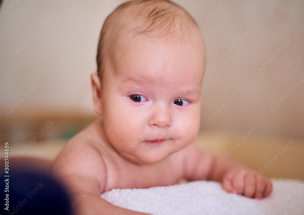 Funny baby lies on his stomach, looks and smiles Funny baby lies on his stomach, looks and smiles