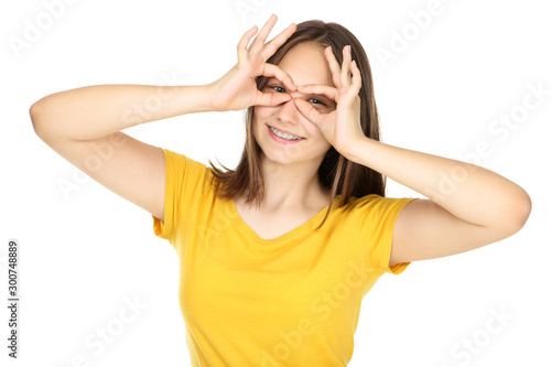 Young girl showing eyes by hands on white background