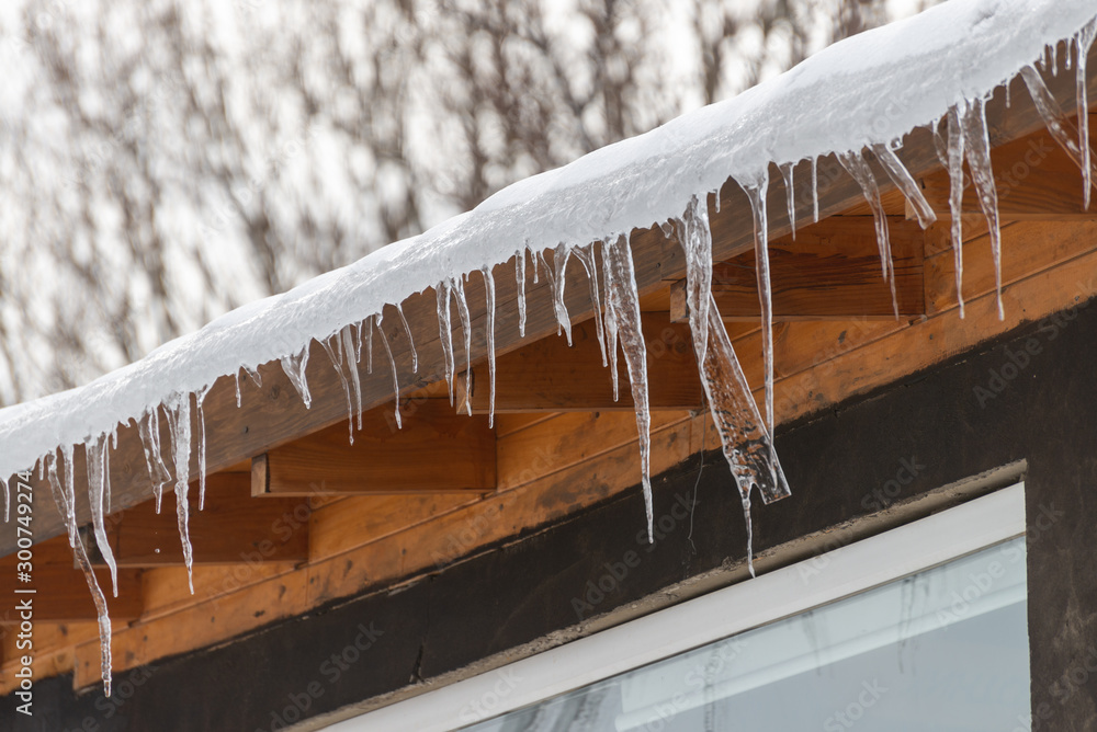 Icicles hanging on the roof of a house Icicles hanging on the roof of a house