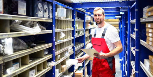 car repair shop employees in the warehouse for spare parts for repairing cars in a garage photo