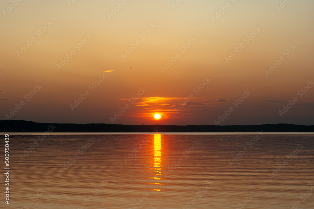 sunset on the background of the sea. the sun sets over the horizon, leaving glare on the water.