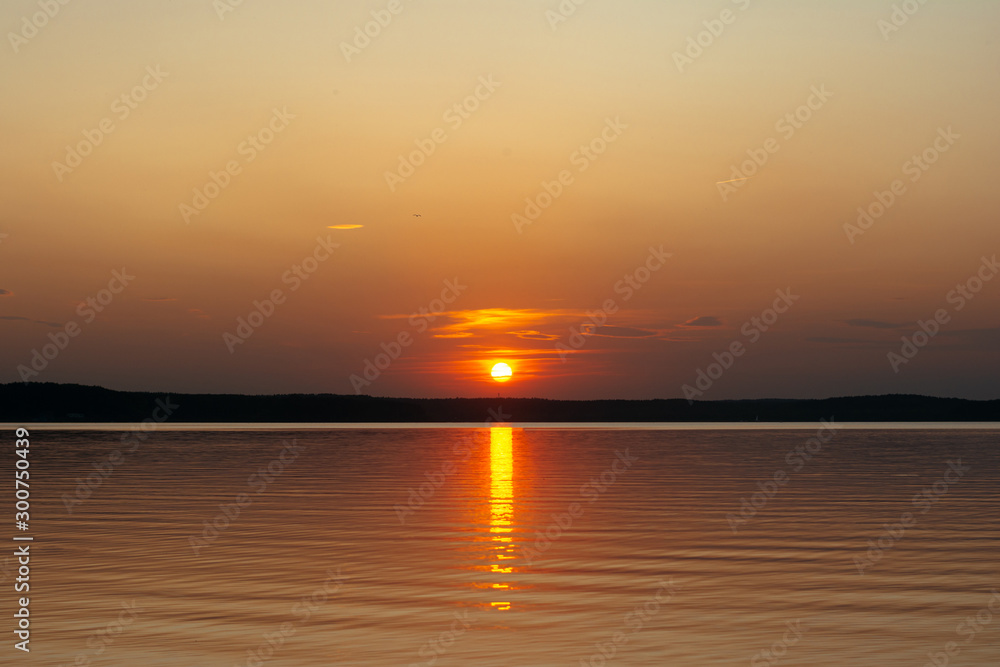 sunset on the background of the sea. the sun sets over the horizon, leaving glare on the water. sunset on the background of the sea. the sun sets over the horizon, leaving glare on the water.