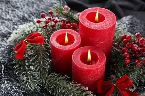 Christmas candles with red berries and fir tree branches
