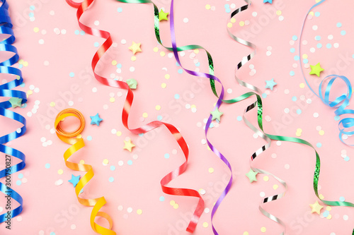 Colorful ribbons confetti and paper stars on pink background © 5second