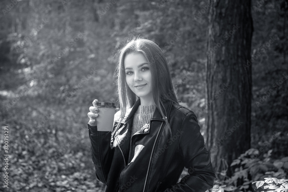 Young woman in autumn park with coffee to go. Young woman in autumn park with coffee to go.