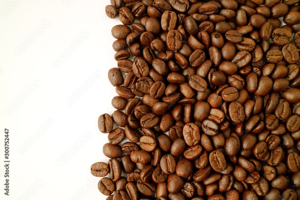 Naklejka premium Dark brown roasted coffee beans isolated on white background with copy space