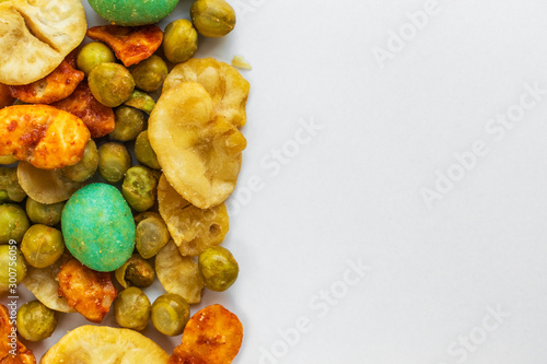 Japanese spicy snacks with peanuts and wasabi are on the left on a white background  on the right is an empty place