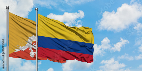 Bhutan and Colombia flag waving in the wind against white cloudy blue sky together. Diplomacy concept, international relations.