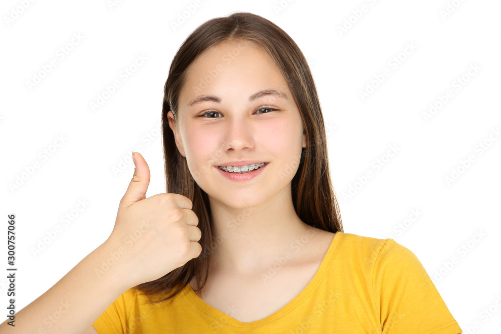 Young girl with dental braces showing thumb up on white background Young girl with dental braces showing thumb up on white background
