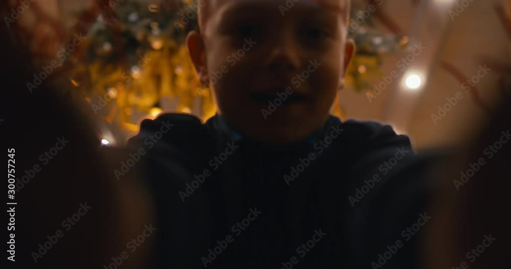 POV view from inside the box, excited cute little kid boy opens Christmas present at home during holidays. 4K UHD RAW graded footage