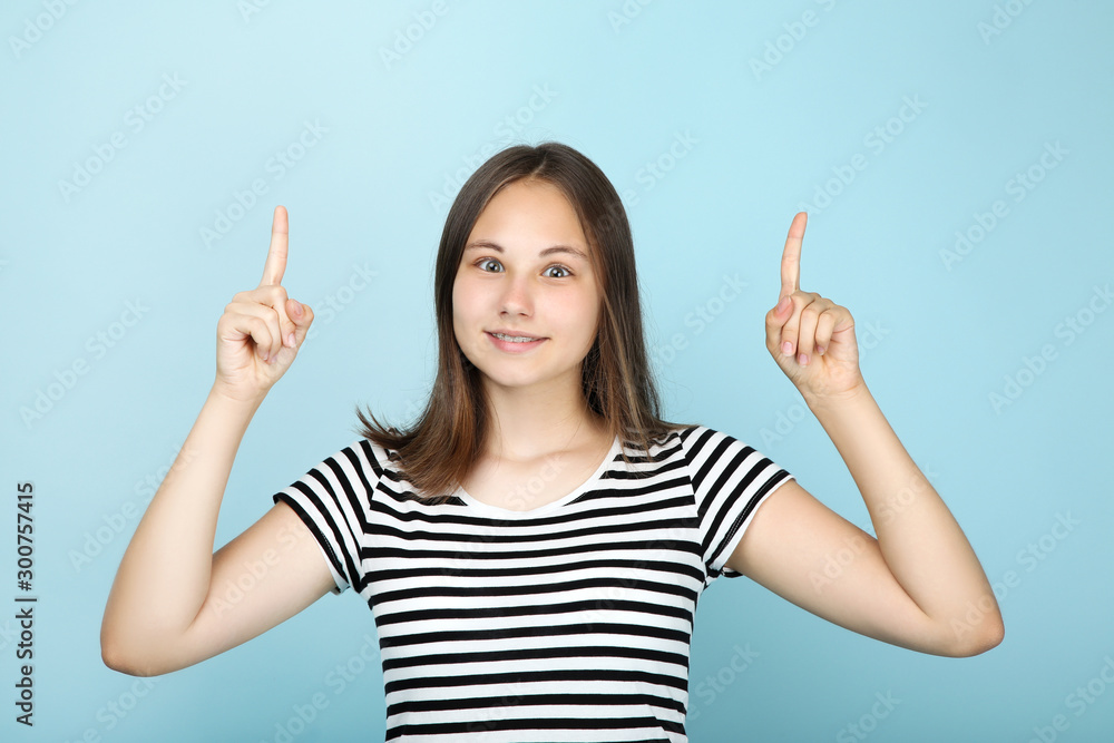 Young beautiful girl showing two fingers up on blue background Young beautiful girl showing two fingers up on blue background