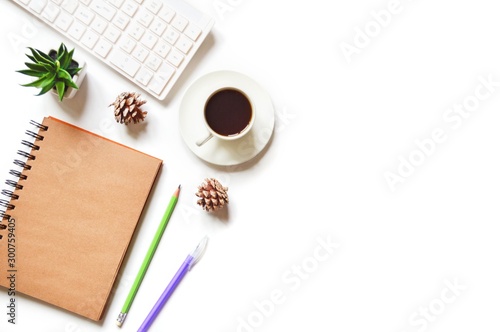 White computer keyboard  diary or paper notebook  green and purple pens  decorative plant  cup of coffee and pine cones. Online job concept. Flat lay photo creative workplace