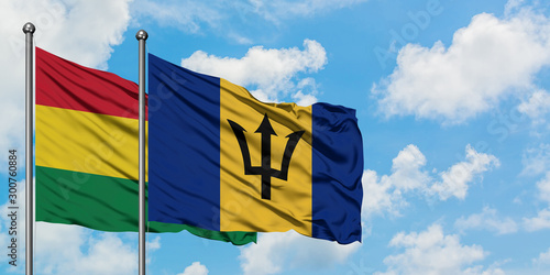 Bolivia and Barbados flag waving in the wind against white cloudy blue sky together. Diplomacy concept, international relations.