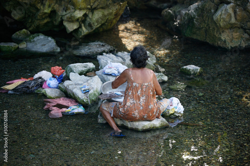 Filipino elderly woman washing clothes in the river. Philippines. Island Katiklan photo