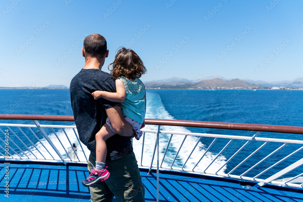 Back view of father and little daughter together on the deck of a ship looking at distance, Mallorca, Spain Back view of father and little daughter together on the deck of a ship looking at distance, Mallorca, Spain