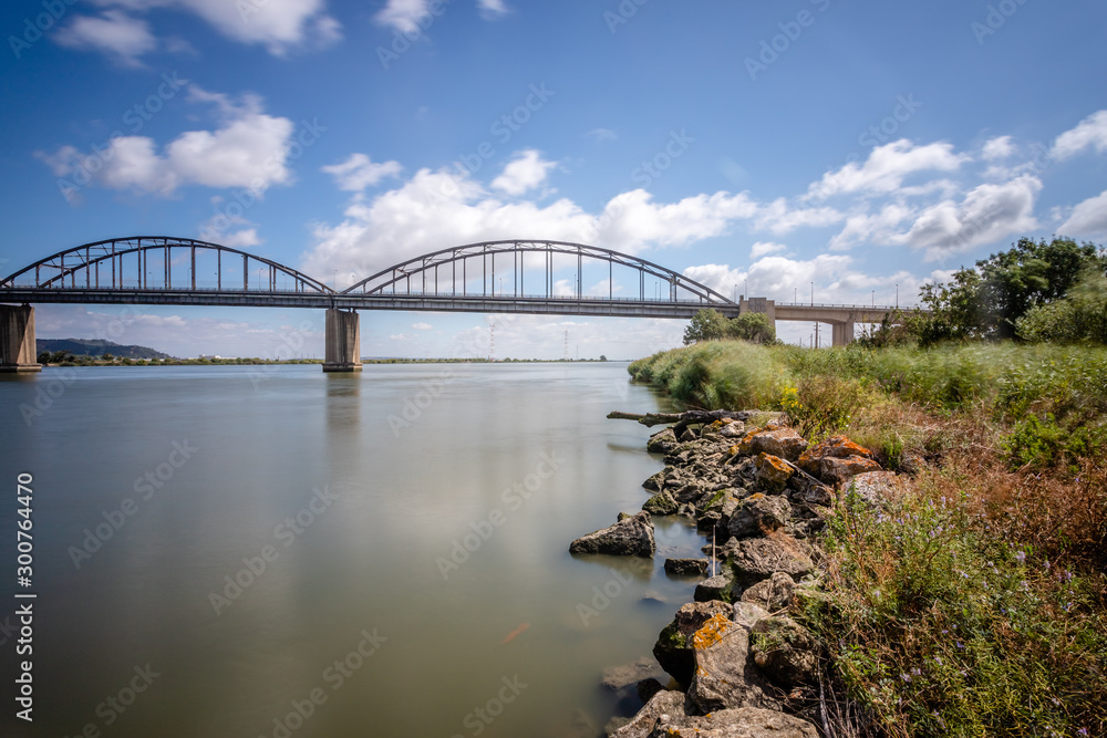 Obraz premium Long exposure landscape image of bridge Marechal Carmona on river Tejo in Vila Franca Xira, Portugal.