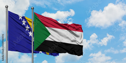 Bosnia Herzegovina and Sudan flag waving in the wind against white cloudy blue sky together. Diplomacy concept, international relations.