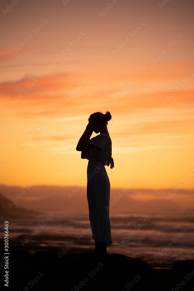 Young blond woman wearing swimsuit at the beach during sunrise