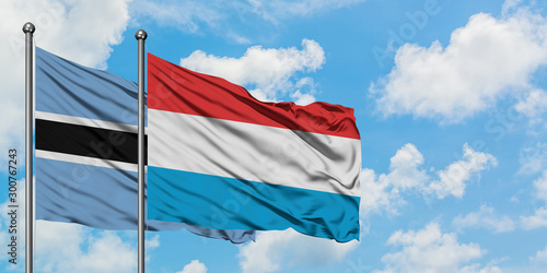 Botswana and Luxembourg flag waving in the wind against white cloudy blue sky together. Diplomacy concept, international relations.