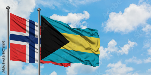 Bouvet Islands and Bahamas flag waving in the wind against white cloudy blue sky together. Diplomacy concept, international relations.