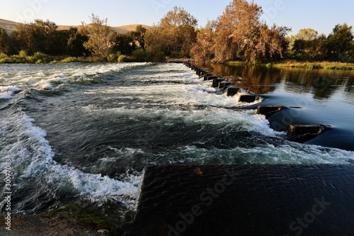 a weir across the Kings River in Fresno County, California slows water flow as it heads downstream to be used for agriculture purposes photo