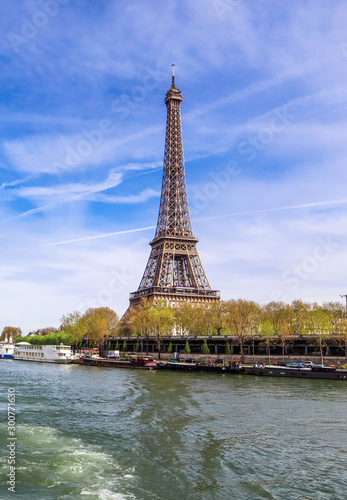 View of Eiffel Tower from Seine river in Paris France against blue sky with clouds. April 2019 © OLAYOLA