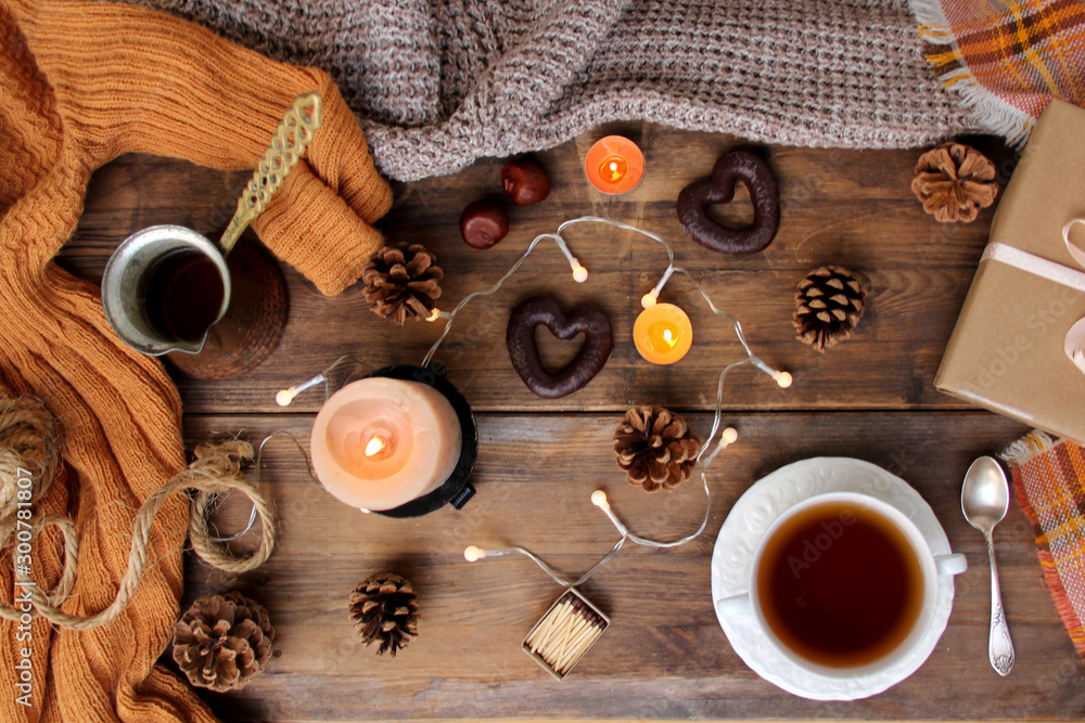 beautiful flat on an old wooden background, a cup of tea and sweets, coffee, candles, a gift in paper, cones, top view, the concept of Christmas and New Year, cozy home, close-up beautiful flat on an old wooden background, a cup of tea and sweets, coffee, candles, a gift in paper, cones, top view, the concept of Christmas and New Year, cozy home, close-up