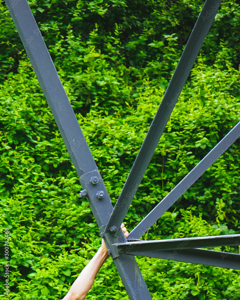 Detailed Close Up of Steel Pylon Framing with Bolted Connection with Arm for Scale Detailed Close Up of Steel Pylon Framing with Bolted Connection with Arm for Scale