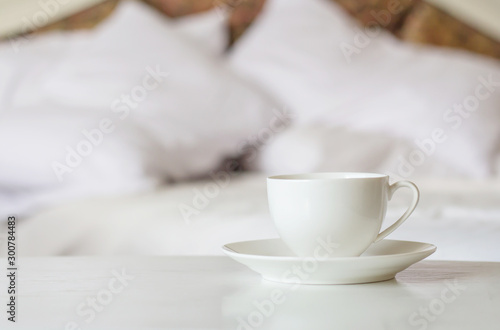 White cup coffee on the bed, wake up concept.