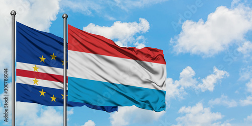 Cape Verde and Luxembourg flag waving in the wind against white cloudy blue sky together. Diplomacy concept, international relations.
