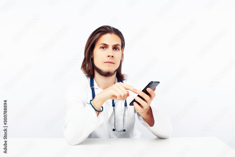 young male doctor with phone posing isolated on white background young male doctor with phone posing isolated on white background