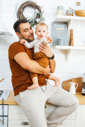 young real father with little cute son todler on kitchen in morning, lifestyle people concept