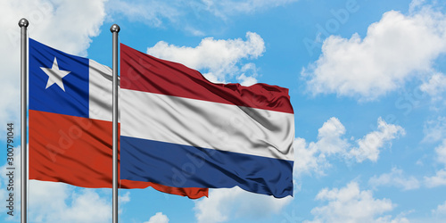 Chile and Netherlands flag waving in the wind against white cloudy blue sky together. Diplomacy concept, international relations.