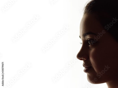 Perfil de joven mujer sobre fondo blanco a contraluz photo