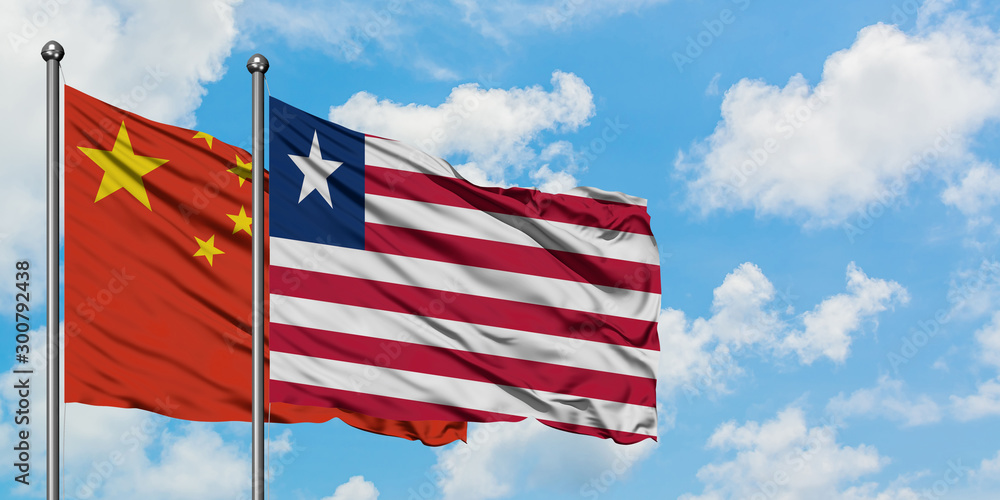 China and Liberia flag waving in the wind against white cloudy blue sky together. Diplomacy concept, international relations. China and Liberia flag waving in the wind against white cloudy blue sky together. Diplomacy concept, international relations.