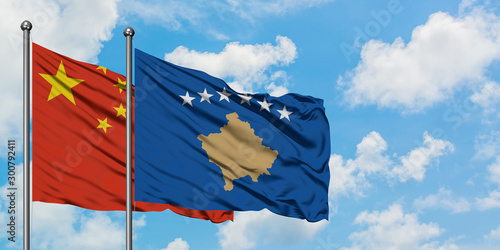 China and Kosovo flag waving in the wind against white cloudy blue sky together. Diplomacy concept, international relations.