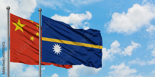 China and Nauru flag waving in the wind against white cloudy blue sky together. Diplomacy concept, international relations.