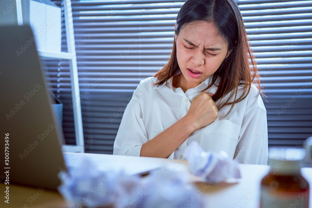 Asian business woman hand pressing on chest with painful expression. Symptoms of heart disease because working too hard. Asian business woman hand pressing on chest with painful expression. Symptoms of heart disease because working too hard.