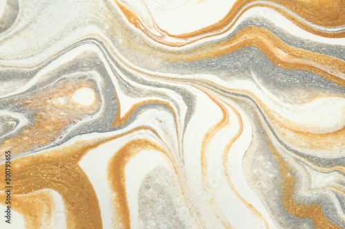 Metallic gold and shimmering silver swirl and blend together in this abstract holiday background. photo