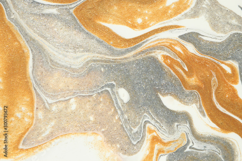 Layers of metallic gold and silver flow gently downwards in this abstract background. photo