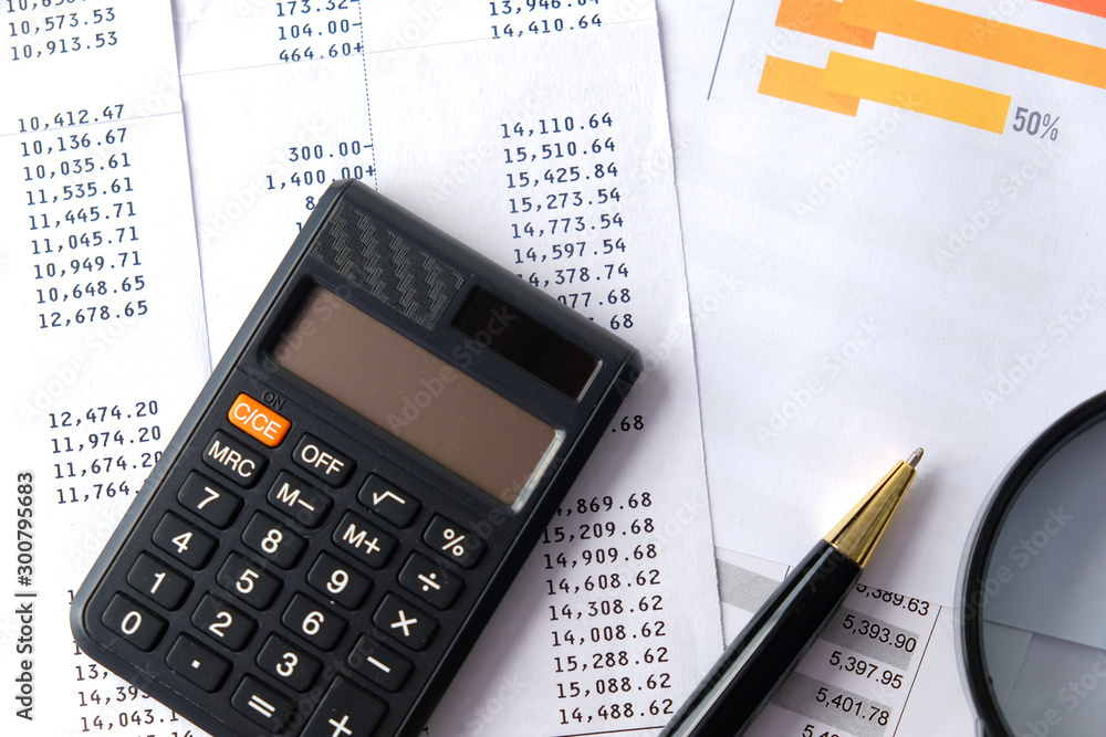 Pen, calculator with magnifier and account reports. Business and Finance concepts Pen, calculator with magnifier and account reports. Business and Finance concepts