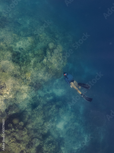 A young girl is swimming on a coral reef 