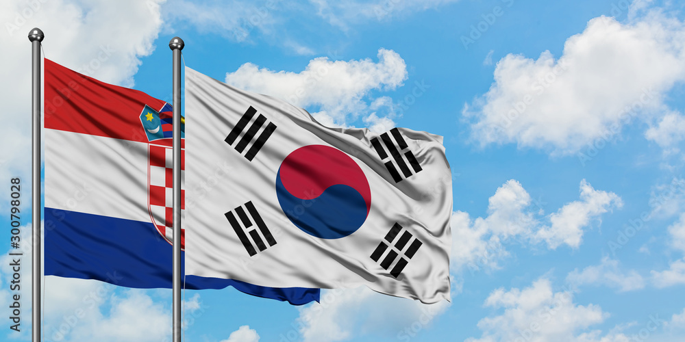 Obraz premium Croatia and South Korea flag waving in the wind against white cloudy blue sky together. Diplomacy concept, international relations.