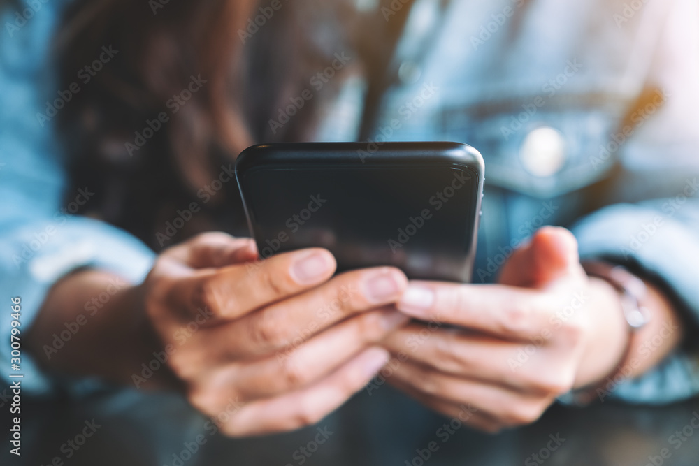Closeup image of a woman holding , using and looking at mobile phone Closeup image of a woman holding , using and looking at mobile phone