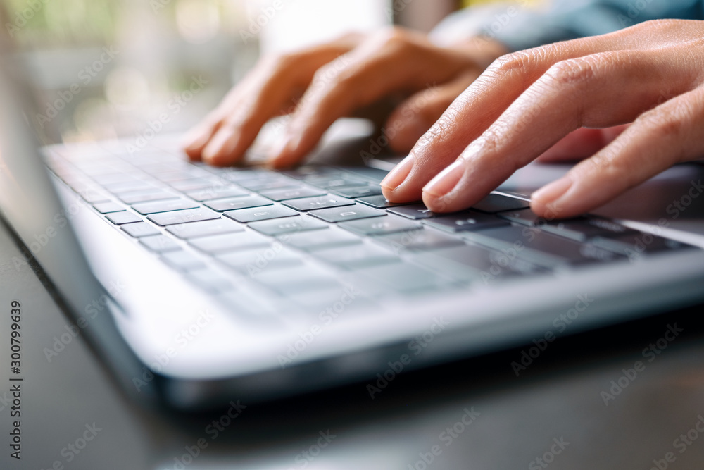 Closeup image of a woman working and typing on laptop computer on the table Closeup image of a woman working and typing on laptop computer on the table