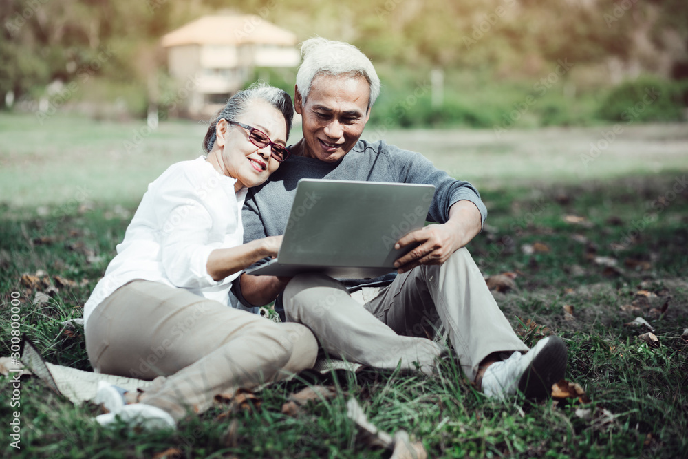 Fototapeta premium Happy older couple doing online shopping, laughing wife pointing at screen of laptop computer.?