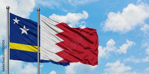 Curacao and Bahrain flag waving in the wind against white cloudy blue sky together. Diplomacy concept, international relations. photo