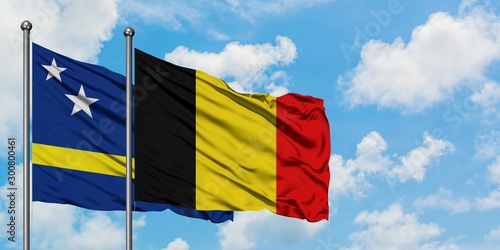 Curacao and Belgium flag waving in the wind against white cloudy blue sky together. Diplomacy concept, international relations. photo