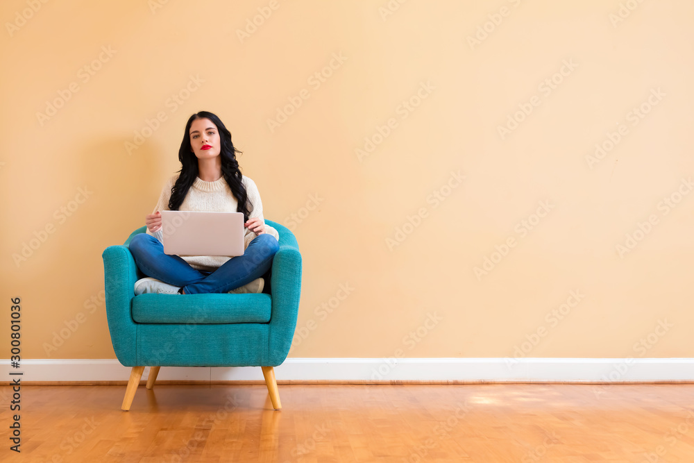 Young woman with a laptop computer sitting in a chair